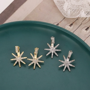 Elegant gold and silver sunflower star stud earrings with crystals on green plate