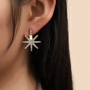 Elegant gold octagonal star stud earrings with pave crystals worn by a model