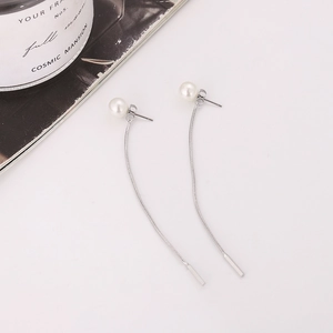 Dettaglio di eleganti orecchini con perle, catene a nappa lunghe e barre in argento