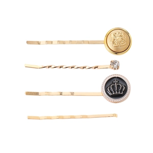 Detail view of 4-piece golden hair clip set with embossed crests and crystal accents