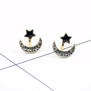 Detailed view of moon and star earrings with golden frame and dark rhinestones