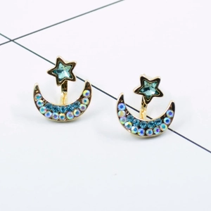 Detail view of gold star and crescent moon earrings with blue crystal inlay and rhinestones