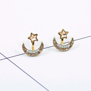 Star and moon gold alloy earrings with pink and white rhinestones on white background