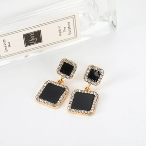 Elegant black square drop earrings with gold plating and crystals on a white background