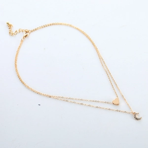 Layered gold necklace featuring a minimalist heart pendant and a moon charm with stones