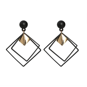 Minimalist geometric drop earrings featuring black spheres and gold rhombus dangles