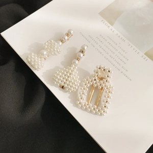 Gros plan détaillé d'un lot de 3 barrettes à perles dorées sur une carte décorative