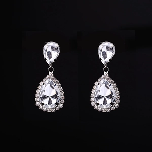 Macro detail of pear-shaped teardrop earrings with halo crystals on black background