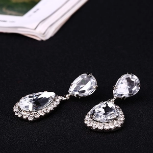 Detail view of pear-cut zircon teardrop earrings with a glittering halo setting