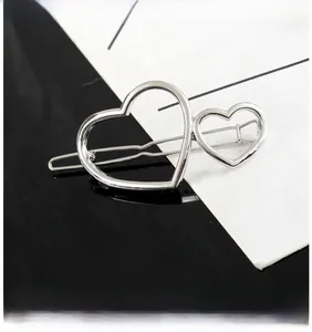Détail de la pince à cheveux argentée en forme de cœur avec double design de cœur entrelacé