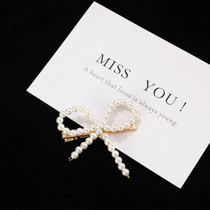 Barrette à cheveux élégante en perles blanches en forme de nœud avec pince dorée
