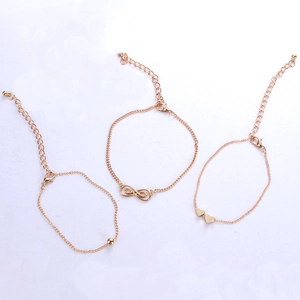 Golden 3-piece bracelet set featuring infinity symbol, twin hearts and bead pendants