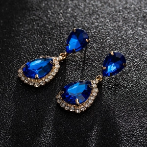 Macro detail of elegant pear-cut blue zircon teardrop earrings with gold plating