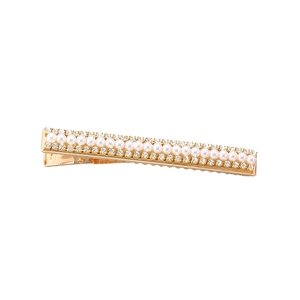 Détails de la barrette dorée ornée de perles blanches et de strass brillants de luxe