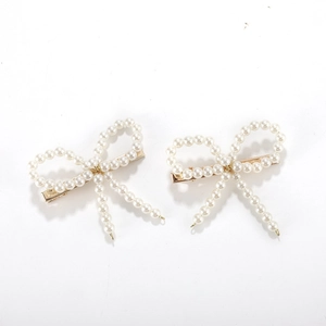 Paire élégante de barrettes dorées avec perles blanches en forme de nœud papillon