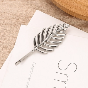 Barrette élégante en forme de feuille évidée argentée sur un fond minimaliste chic
