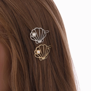 Set di fermagli a conchiglia con strass e perle su capelli castani esposti
