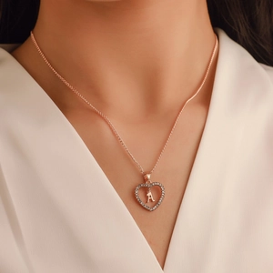 Collier cœur or rose avec cristaux pavés et lettre A, porté par un mannequin