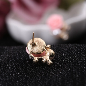 Macro view showing the golden metal back structure and pin of the pearl flower earring