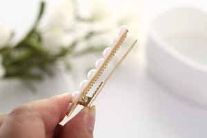 Vue détaillée de la barrette à perles dorées avec conception antidérapante dentelée