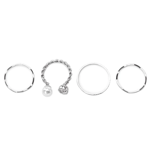 Ensemble de quatre bagues géométriques argentées avec perles et cristaux sur fond blanc