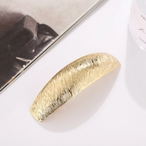 Fashionable golden arched metal hair clip with vertical textured pattern for women
