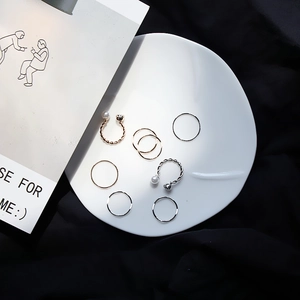 Détail d'un ensemble de 7 bagues minimalistes avec perles et textures torsadées sur céramique