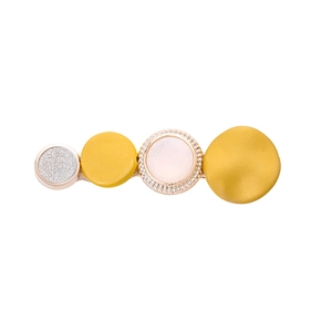 Détail d'une pince à cheveux aux couleurs bonbon avec texture mate et disques ronds pailletés