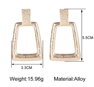 Détail de boucles d'oreilles dorées géométriques avec texture et mesures de 5,5 cm