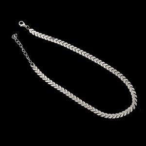 Macro detail of silver V-shape fishbone chain with lobster clasp and adjustable extension