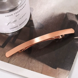 Barrette à cheveux minimaliste en or rose avec finition brossée mate sur magazine