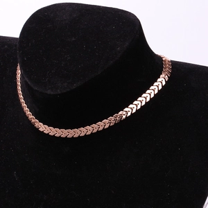 Detail view of rose gold fishtoin chain necklace with geometric arrow links on mannequin