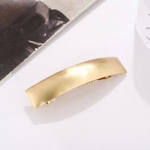 Minimalist rectangular matte gold metal hair clip with brushed finish texture