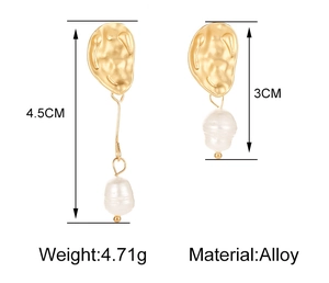 Detailed view of asymmetrical alloy earrings with hammered gold plates and pearls