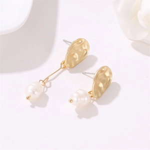 Detail of matte gold irregular wave earrings with elegant freshwater pearls on white