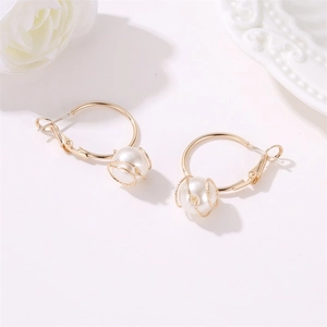 Elegant gold metal wire wrapped pearl drop earrings on minimalist white background