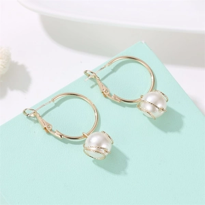 Detailed view of 18K gold hoop earrings with wire-wrapped white pearl pendants