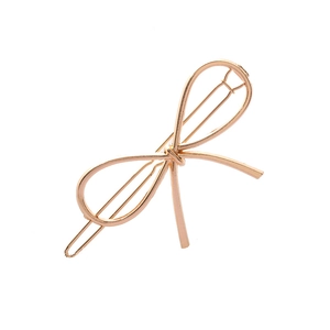 Détail de la pince à cheveux noeud en or rose avec un design en métal poli épuré