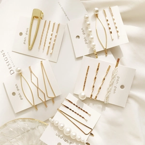 Détail de l'ensemble de quatre barrettes à perles en alliage doré sur cartes de présentation