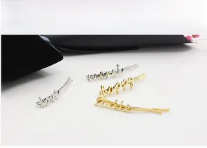 Detailed close-up of gold and silver alloy hair clips with love and smile lettering