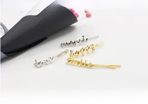 Detailed view of metal word hair clips featuring love, happy, and smile inscriptions