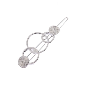 Détail de la barrette géométrique argentée avec cercles superposés sur une base fine