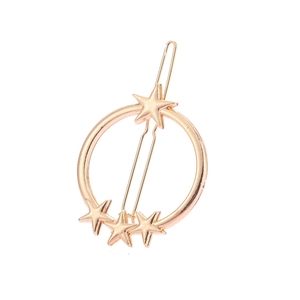 Détail macro d'une barrette circulaire dorée ornée d'étoiles sur fond blanc pur et net