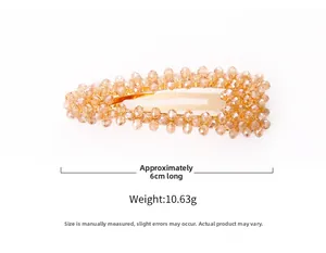 Détail d'une pince à cheveux de 6 cm ornée de perles en cristal champagne et doré