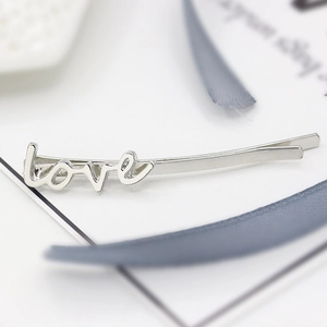 Minimalist silver LOVE letter hair clip with polished alloy finish on white background
