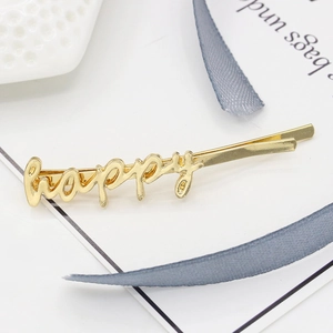 Minimalist golden alloy hair clip featuring a stylish happy word script design