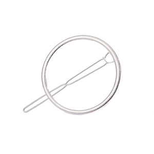 Détail d'une pince à cheveux circulaire minimaliste en métal argenté avec épingle ondulée
