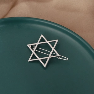 Elegant silver star-shaped metal hair clip on a premium deep green display plate