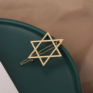 Detailed view of a golden hexagram star hair clip with a polished metallic finish