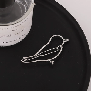 Nahaufnahme der minimalistischen silbernen Vogel-Haarklammer mit glänzender Oberfläche